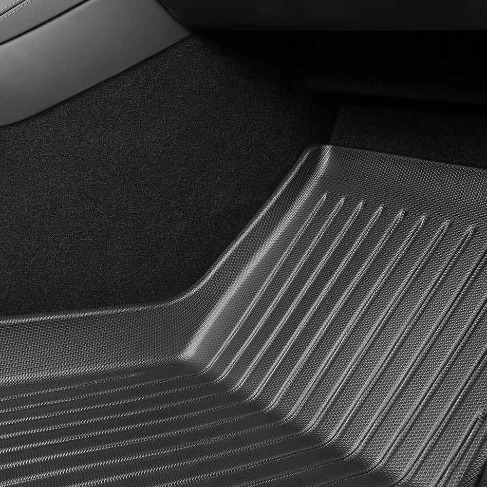 Raised-edge TPE floor mat fitted in the front passenger footwell of Model Y
