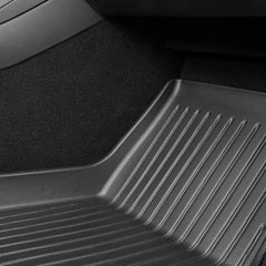 Raised-edge TPE floor mat fitted in the front passenger footwell of Model Y