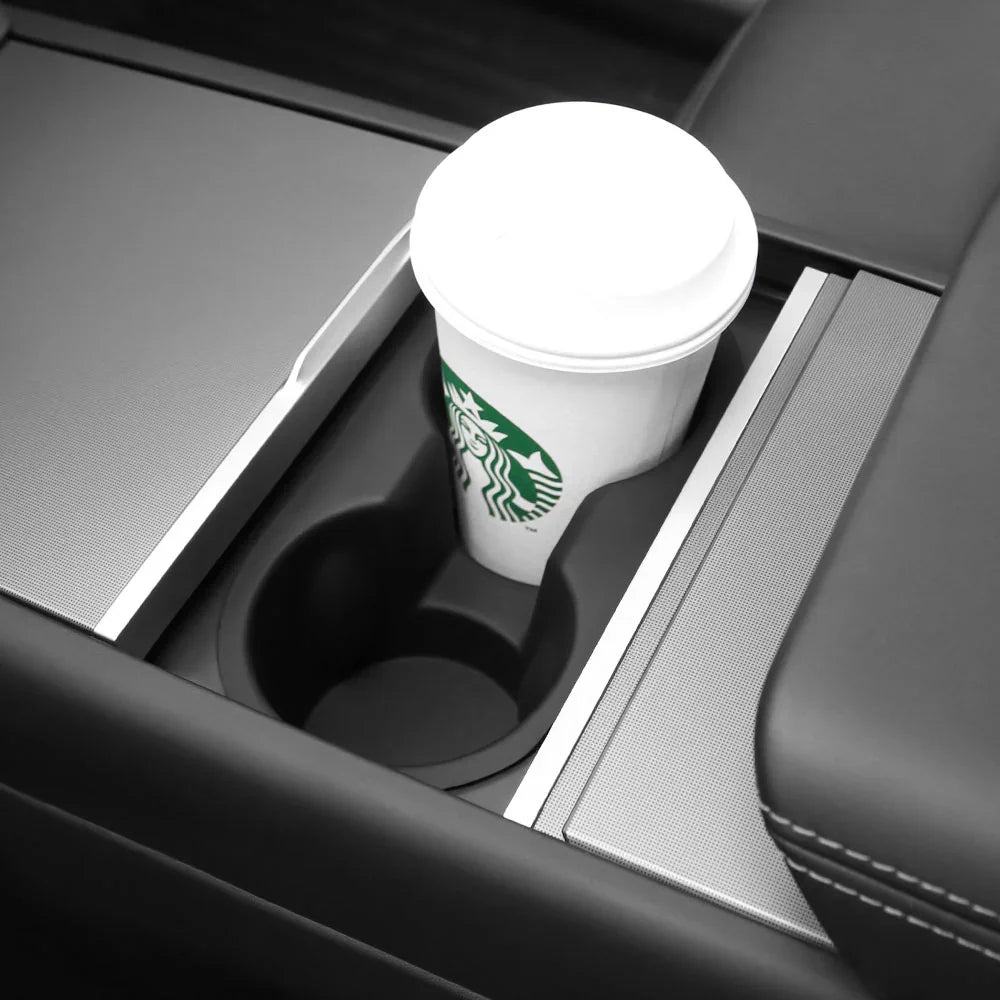 Cup holder insert securely holding a takeaway coffee cup in Model 3 and Model Y