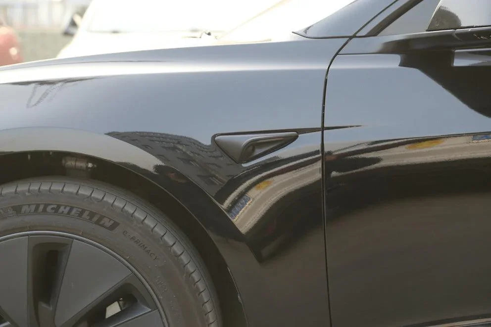 Side view of Model Y with matt black side indicator camera caps installed