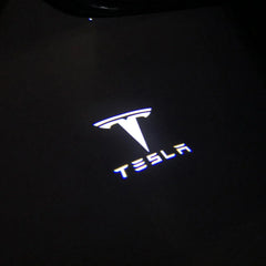 Tesla logo puddle light projection on the ground at night