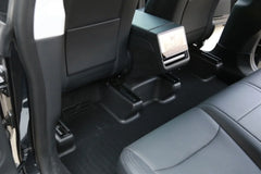 Under seat carpet protector viewed from behind the driver's seat