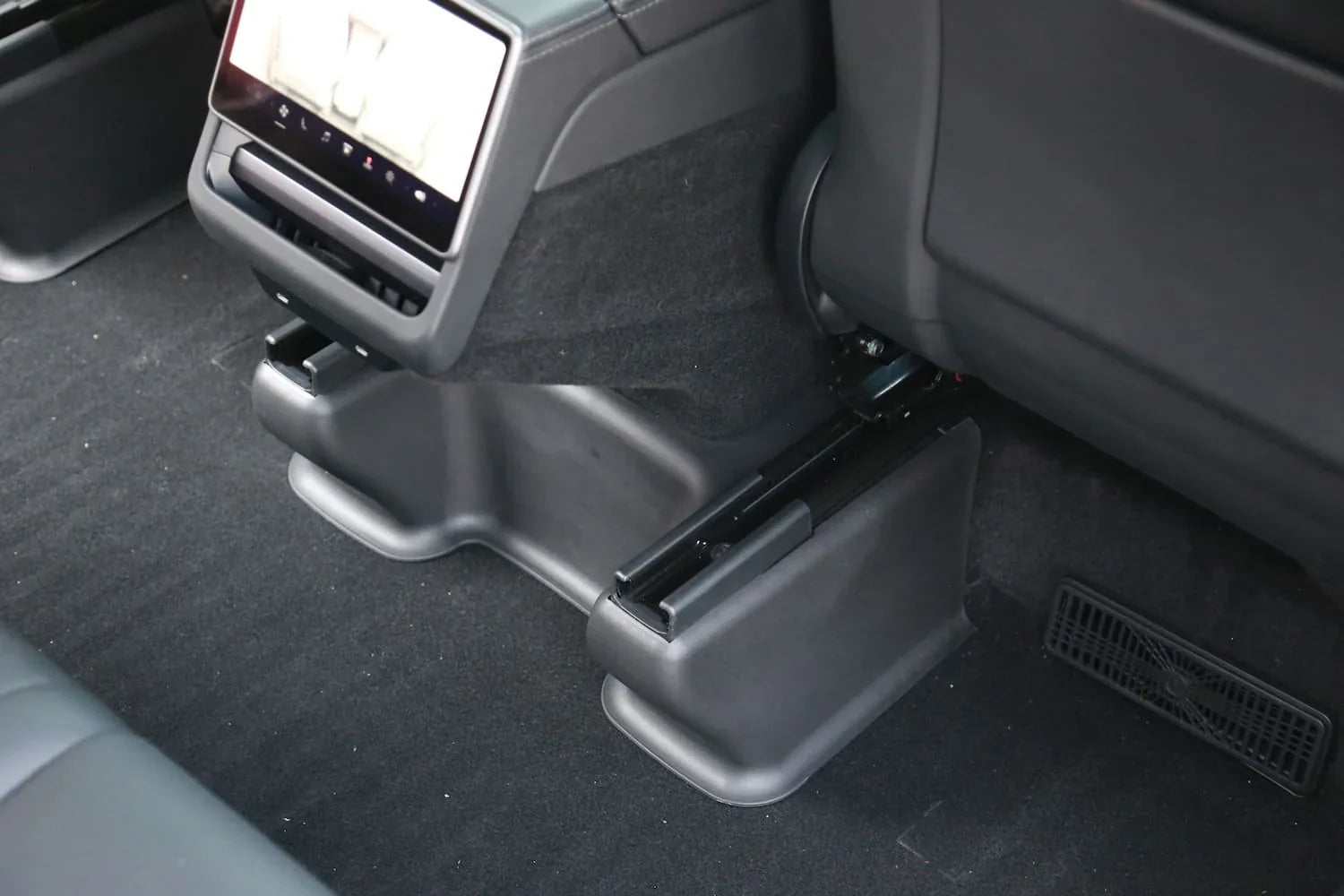 Under seat carpet protector viewed from behind the front passenger seat