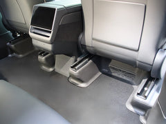 Rear under seat carpet protectors installed in the second-row footwell of Model Y L