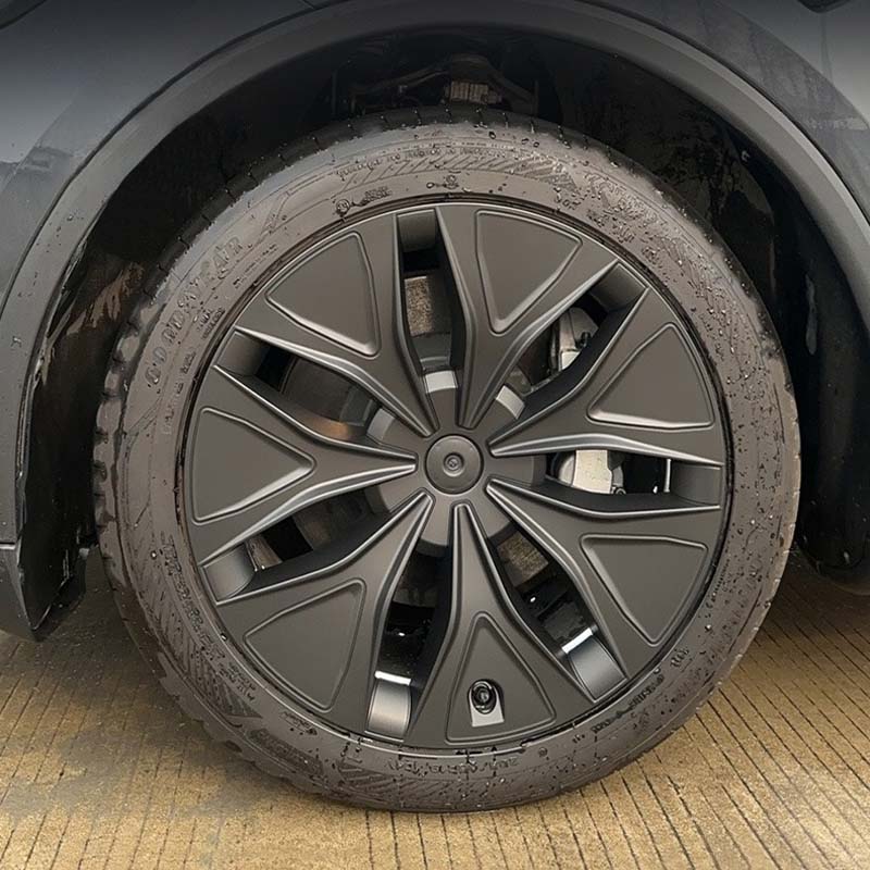 Close-up view of the installed 19-inch matt black aero wheel cover on Model Y L