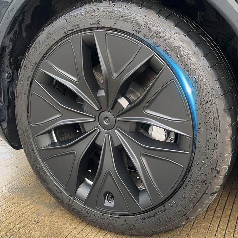 Close-up of the 19-inch matt black aero wheel cover installed on Model Y L