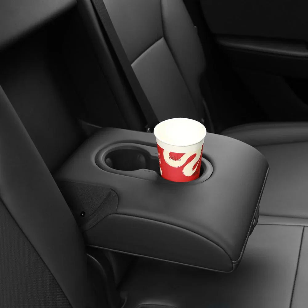 Rear cup holder insert securely holding drinks in the Model Y rear armrest