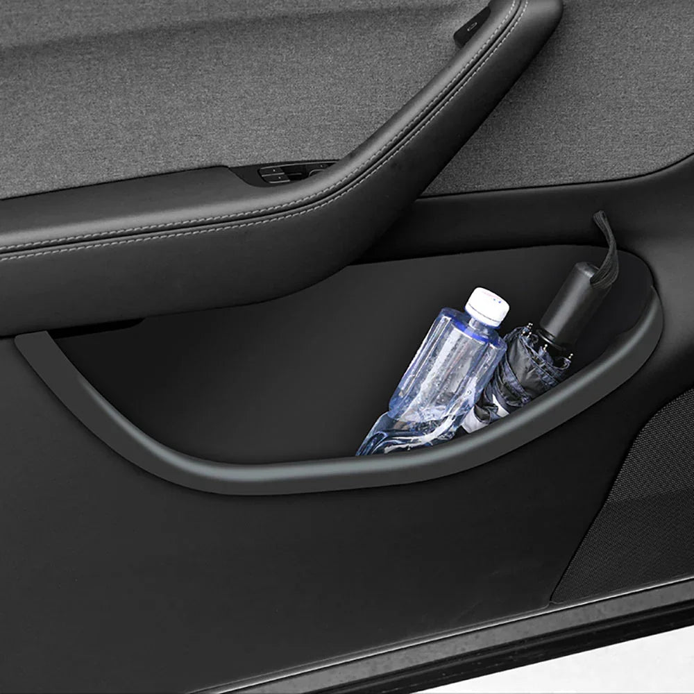 Door storage tray holding a water bottle in the Model Y door pocket
