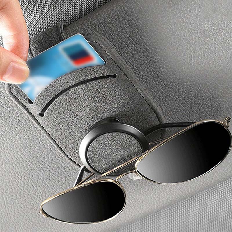 Car glasses holder clip securely holding a pair of glasses on the sun visor