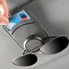 Car glasses holder clip securely holding a pair of glasses on the sun visor