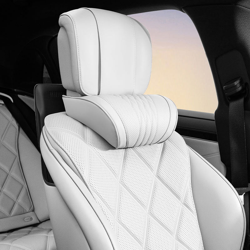 White Nappa leather neck support pillow installed on a vehicle seat