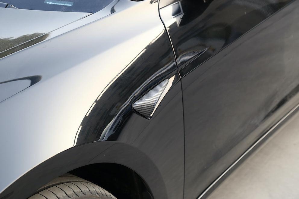 Side view of Model Y with carbon fibre side indicator camera caps installed
