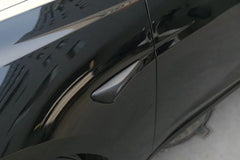 Matt black side indicator camera cap installed beside the side camera on Model Y