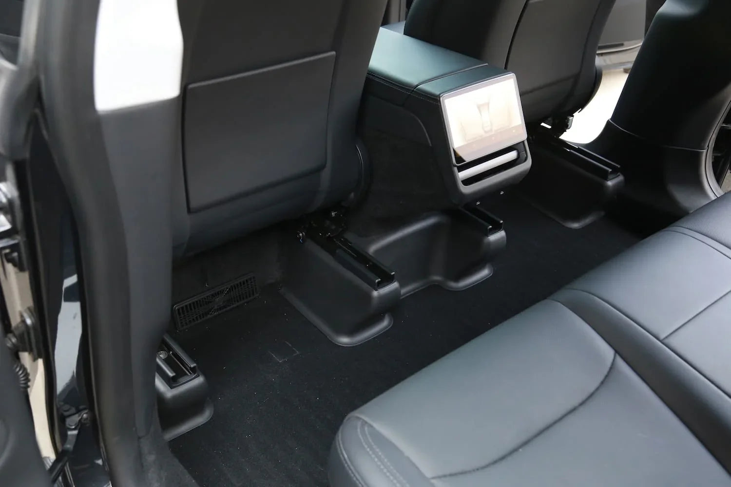 Under seat carpet protector viewed from behind the driver's seat